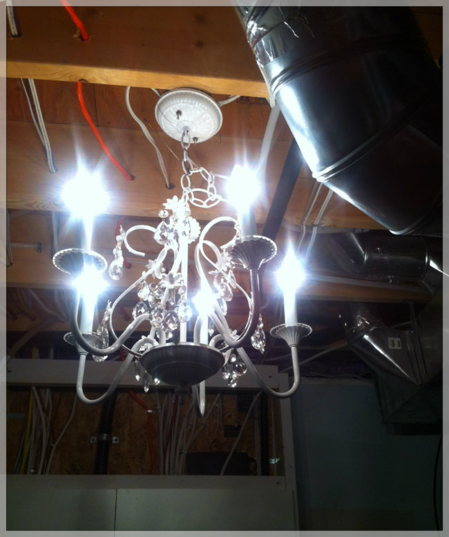 A chandelier hanging from the rafters in the laundry room. Poster by Bergen and Associates.